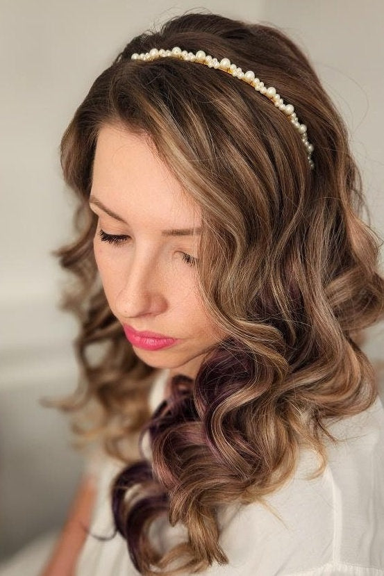 Model with textured waves wearing a thin pearl bridal headband, showcasing a simple yet elegant accessory perfect for adding subtle sparkle to any bridal hairstyle. Ideal for understated, romantic wedding looks.