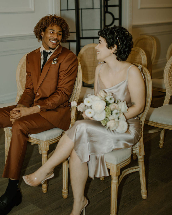Man and woman sitting together in a formal setting, possibly a wedding or event.