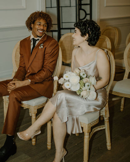 Man and woman sitting together in a formal setting, possibly a wedding or event.