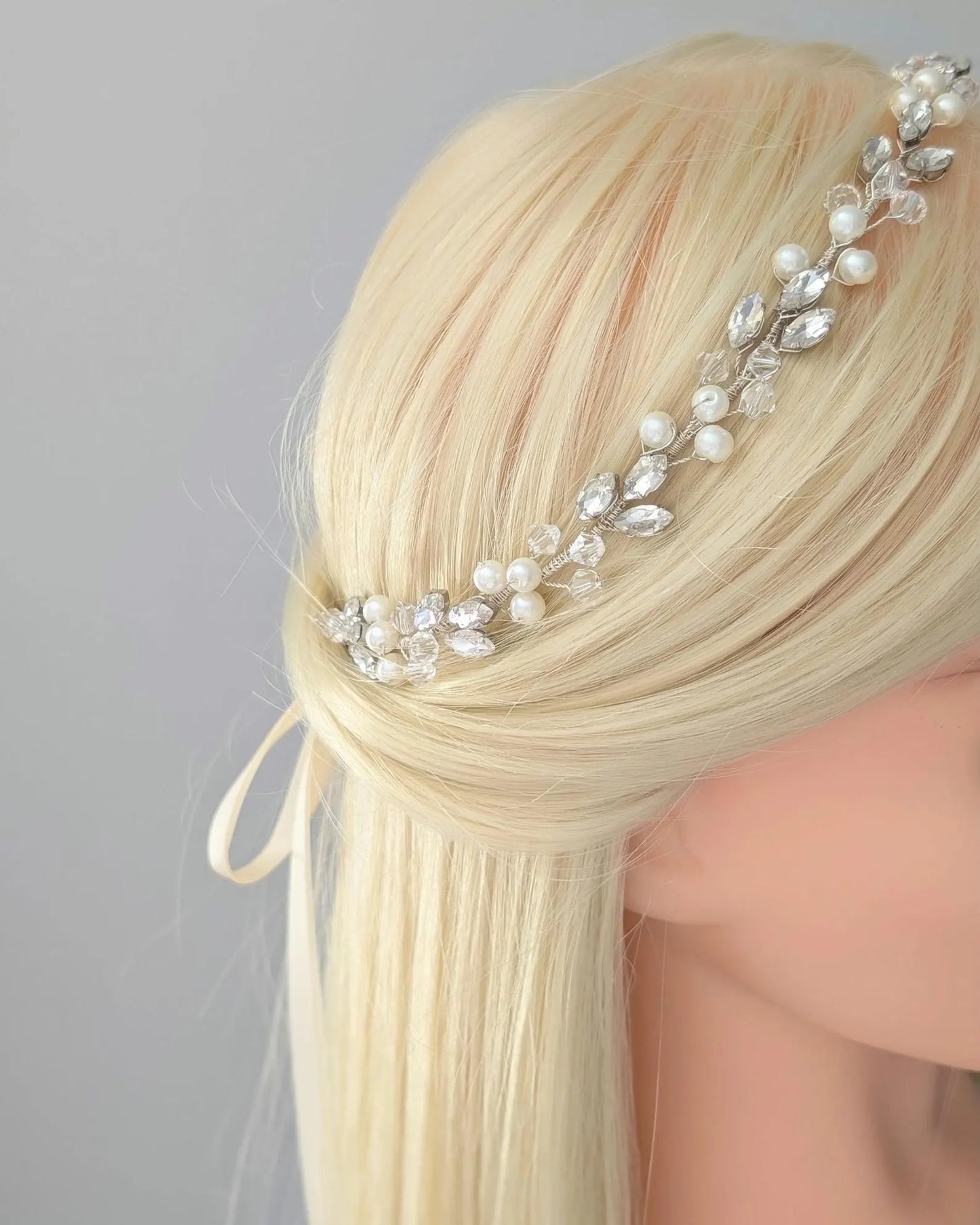 Blonde hair with a decorative headband featuring pearls and crystals on a gray background